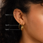Close-up of an ear wearing the Bold Earrings Stack Set—featuring a stud, thin hoop, and thick hoop—to showcase a chic layered look with gold earrings.