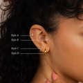 Close-up of a woman's ear adorned with the Diamond Butterfly Earrings Set; her hand rests near her chin.