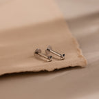 Close up of silver North Star Stud Earrings with flat backs. The earrings feature a north star design with a diamond earring in the middle