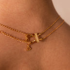 Close-up of a gold necklace with small heart and rectangular charms layered on a neck, featuring stylish stacking using the Double Layering Clasp in Silver for secure dual-lobster-clasp wear.