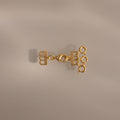 The Triple Layering Clasp in 18K Gold features three loops—ideal for organizing your gold and silver necklaces or creating a chic layered look on any neutral background.