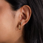 Close-up of a woman's ear wearing Baguette Birthstone Drop Studs, highlighting their modern jewelry style.