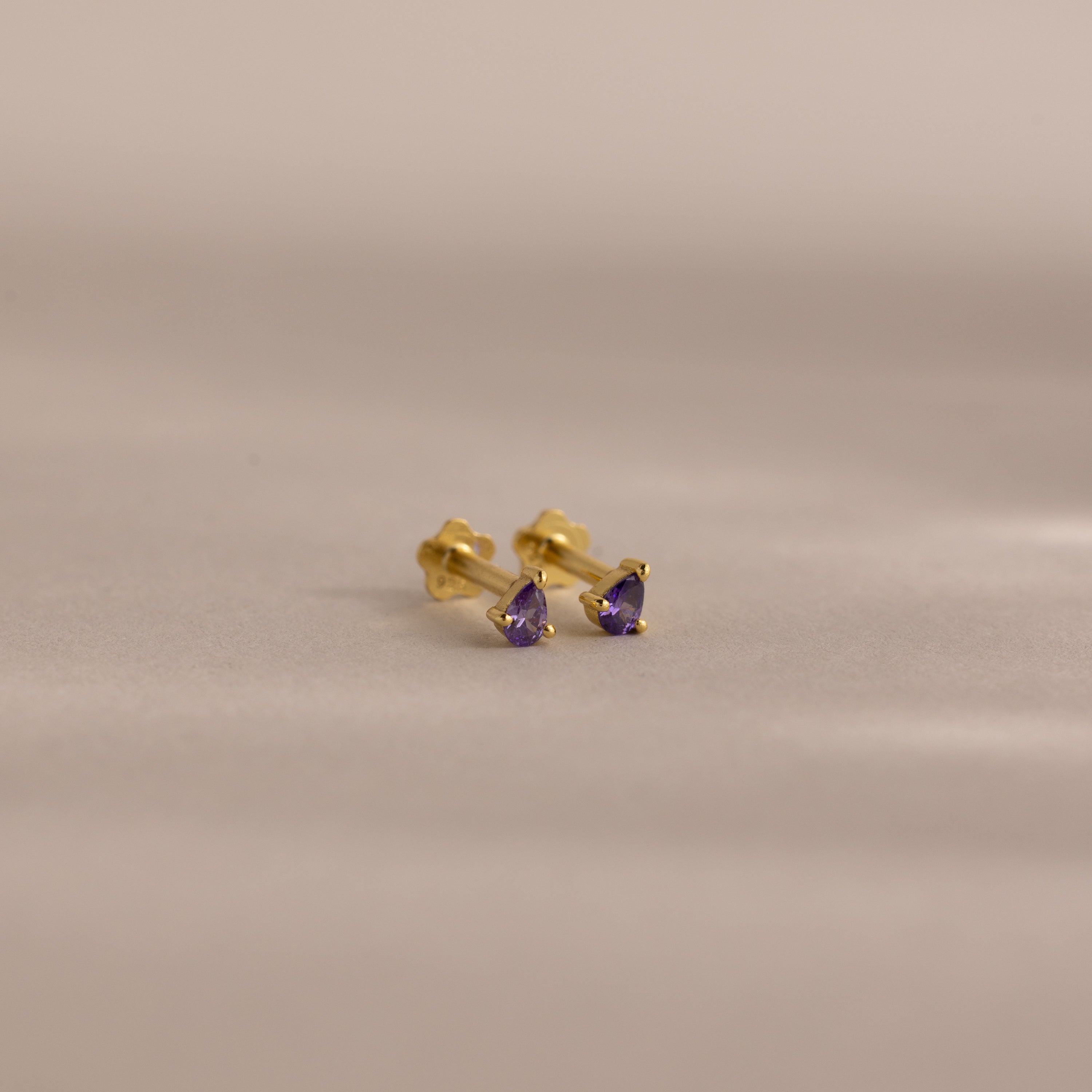 A pair of Teardrop Amethyst Flatback Studs featuring purple stones—ideal as birthstone jewelry or a thoughtful birthday gift.