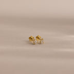 A pair of Teardrop Diamond Flatback Studs—small gold earrings set with clear gemstones—displayed on a neutral background.
