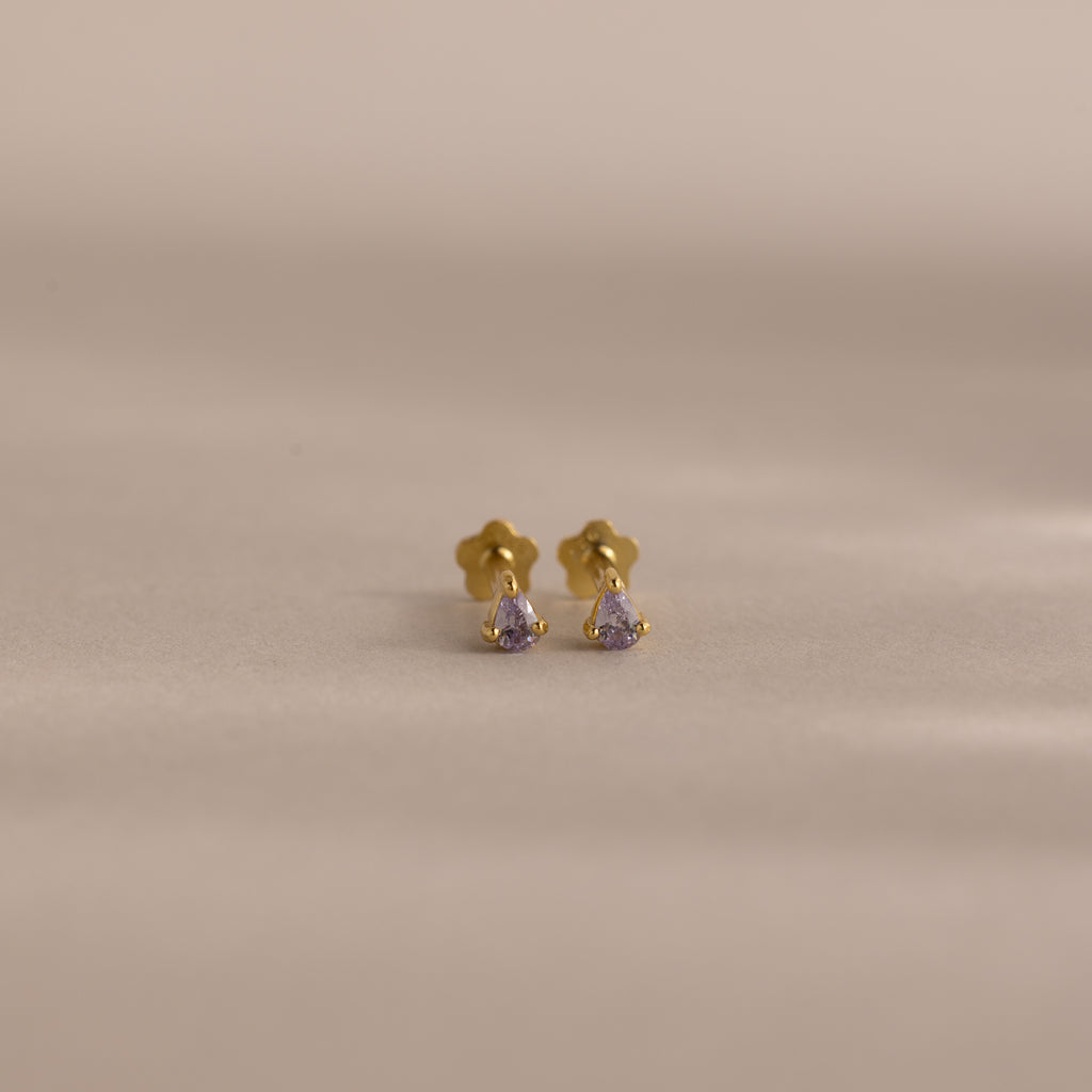 Teardrop Alexandrite Flatback Studs with small purple gemstones, displayed on a light beige background—ideal for those seeking elegant birthstone jewelry.