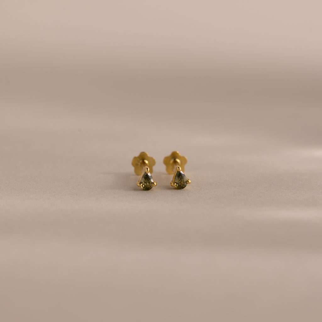 A pair of Teardrop Peridot Flatback Studs, small gold earrings with vibrant peridot stones, perfect as a jewelry gift, displayed on a neutral background.