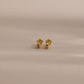 Teardrop Topaz Flatback Studs with flower-shaped backs, shown on a softly lit neutral background—delicate birthstone earrings that make an ideal personalized gift.