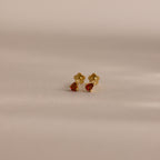 Teardrop Garnet Flatback Studs with gold teardrop settings and red gemstones are displayed on a neutral, light background—an elegant birthstone jewelry piece and a thoughtful birthday gift.