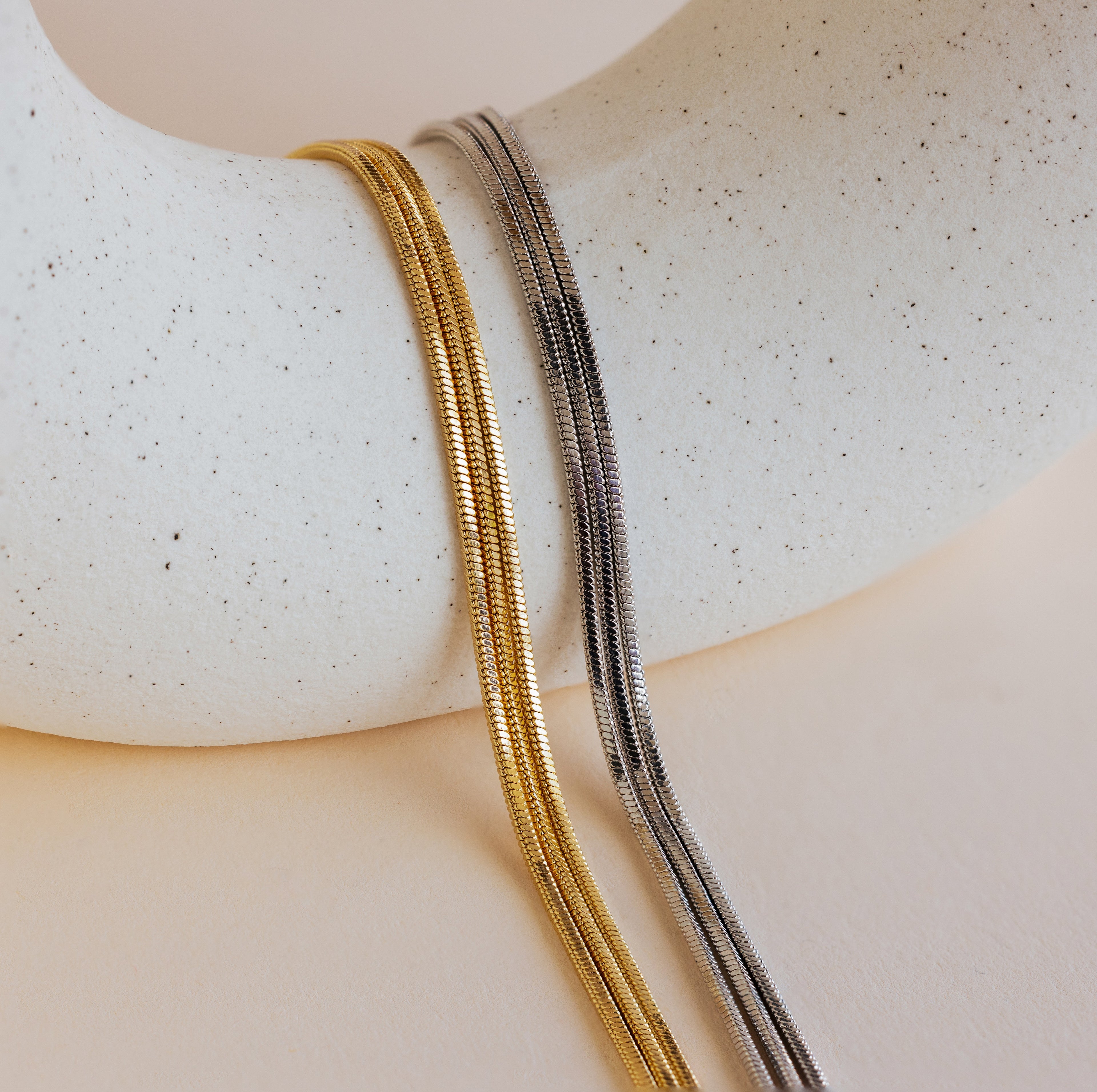 The Triple Snake Chain Bracelet, with its chic gold and silver chains, offers a stylish layered look that’s perfect for fans of minimal jewelry.