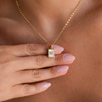 A hand with pale pink nails holds the Pearl Initial Tag Necklace, a customizable gold chain with an M pendant—perfect as a Christmas gift.