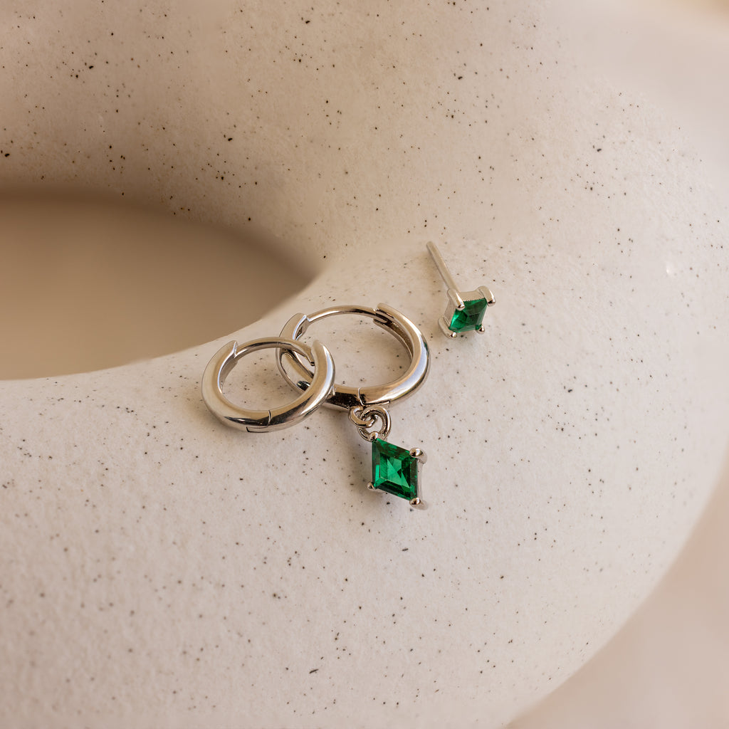 The Emerald Earrings Set is elegantly displayed on a white surface.