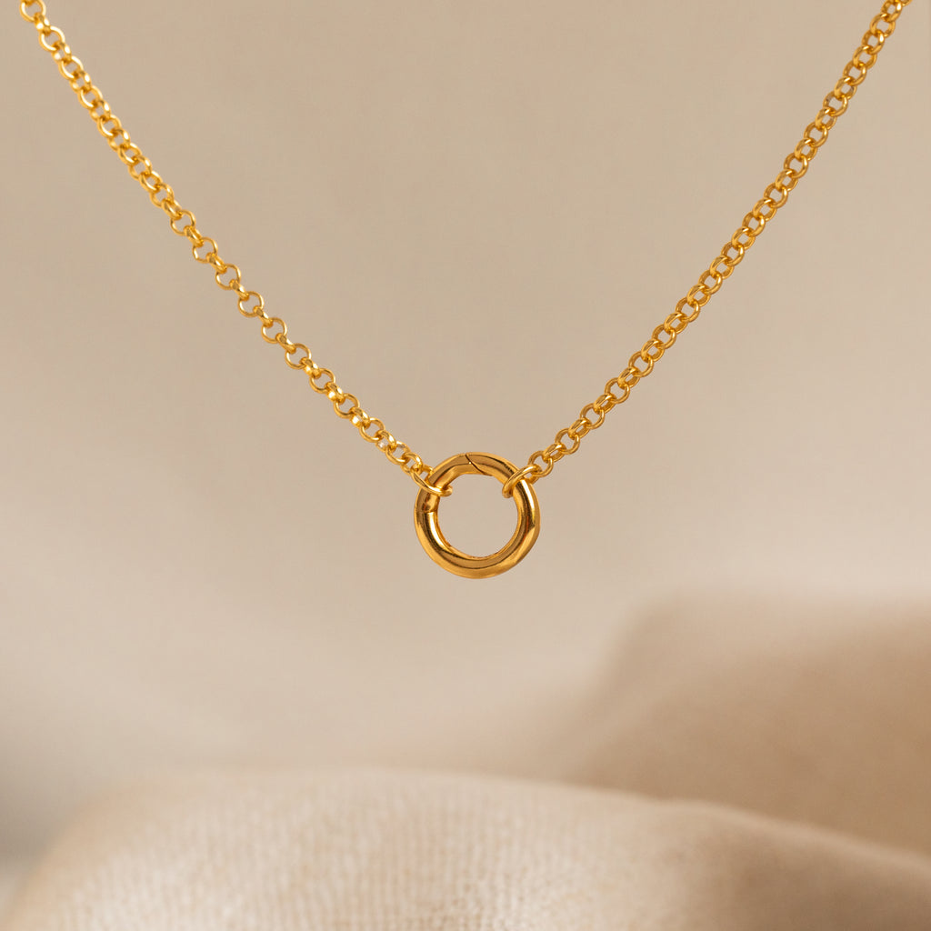Minimalist gold necklace featuring a delicate chain with a small interlocking circle pendant for a timeless, modern look.
