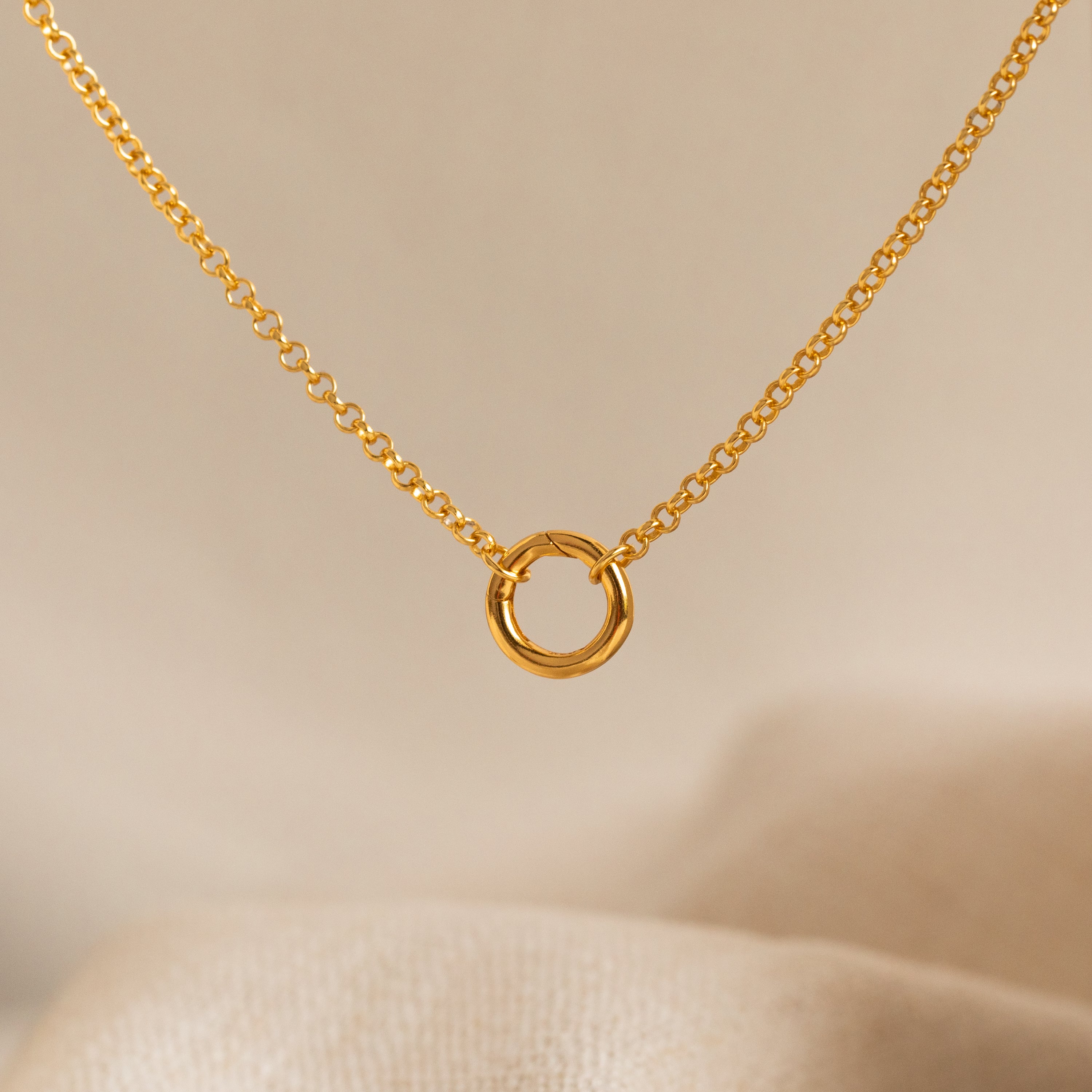 Minimalist gold necklace featuring a delicate chain with a small interlocking circle pendant for a timeless, modern look.
