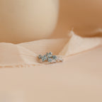 Pair of Aquamarine Diamond Huggies in Sterling Silver stacked on top of each other 