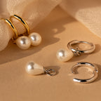 Dainty Pearl Drop Huggies—gold and silver hoops adorned with pearl charms—add elegant sophistication to any look. Displayed on a beige fabric background, these delicate earrings are perfect for chic styling.