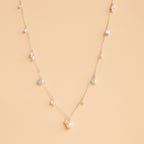 The Baroque Pearl Station Necklace in Sterling Silver, a delicate minimalist piece ideal for wedding jewelry, is displayed on a light beige background.