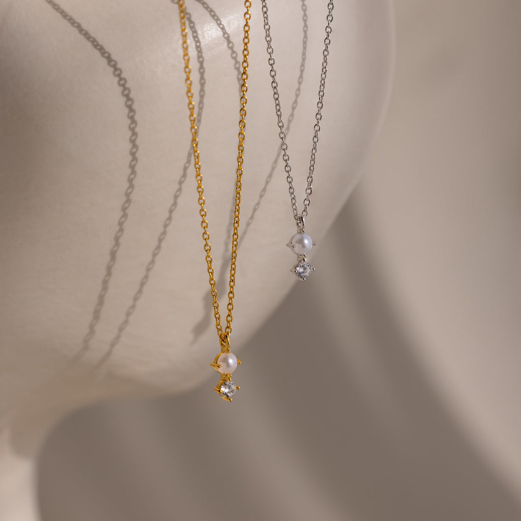 The Pearl Diamond Drop Necklace in 18K Gold, featuring pearl and diamond pendants, is displayed on a white mannequin bust—an elegant choice for bridal jewelry.
