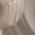 The Pearl Diamond Drop Necklace in Silver, ideal bridal jewelry, is displayed on a smooth, light-toned mannequin bust.