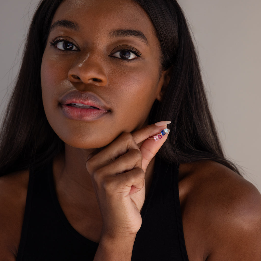 A woman with long dark hair shows off colorful nail art and the Toi et Moi Birthstone Ring in Sterling Silver—an elegant, customizable piece that's a perfect Christmas gift—while wearing a black top.