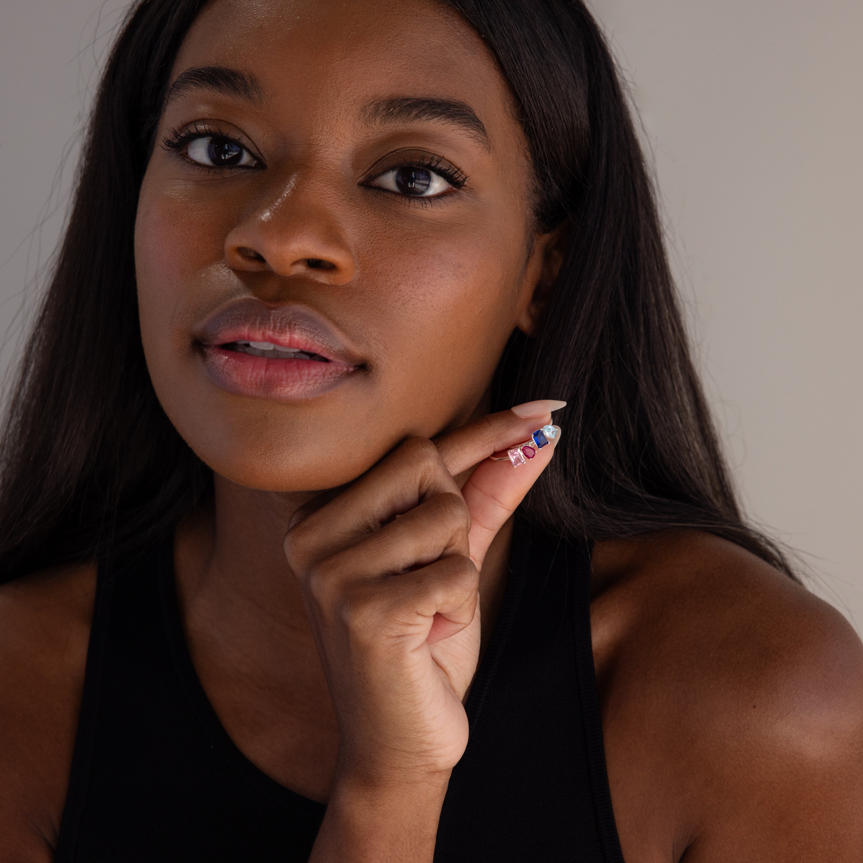 A woman with long dark hair shows off colorful nail art and the Toi et Moi Birthstone Ring in Sterling Silver—an elegant, customizable piece that's a perfect Christmas gift—while wearing a black top.