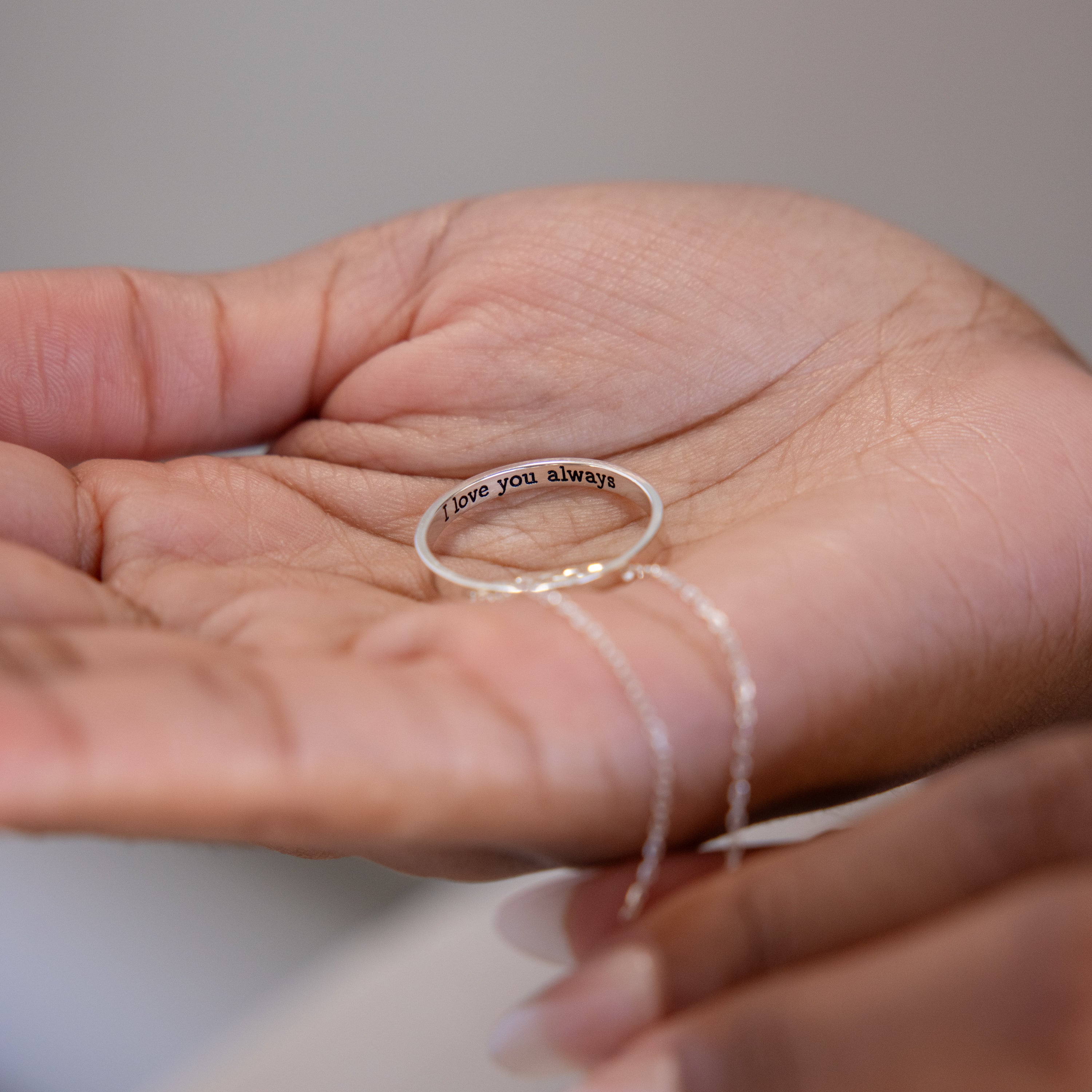 A hand holds the Inner Circle Necklace in Sterling Silver, engraved inside with "love you always," echoing the sentiment of a cherished amulet pendant and chain.
