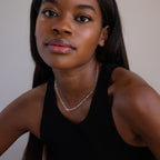 Woman with long dark hair wears a black sleeveless top and the Dainty Link Chain Necklace in Sterling Silver, looking at the camera.