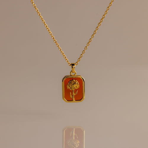 Garnet Birth Flower Charm Necklace featuring a rectangular pendant with an engraved flower design on an orange background.