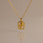 Opal Birth Flower Charm Necklace with a rectangular pendant featuring a flower design, displayed on a plain background.