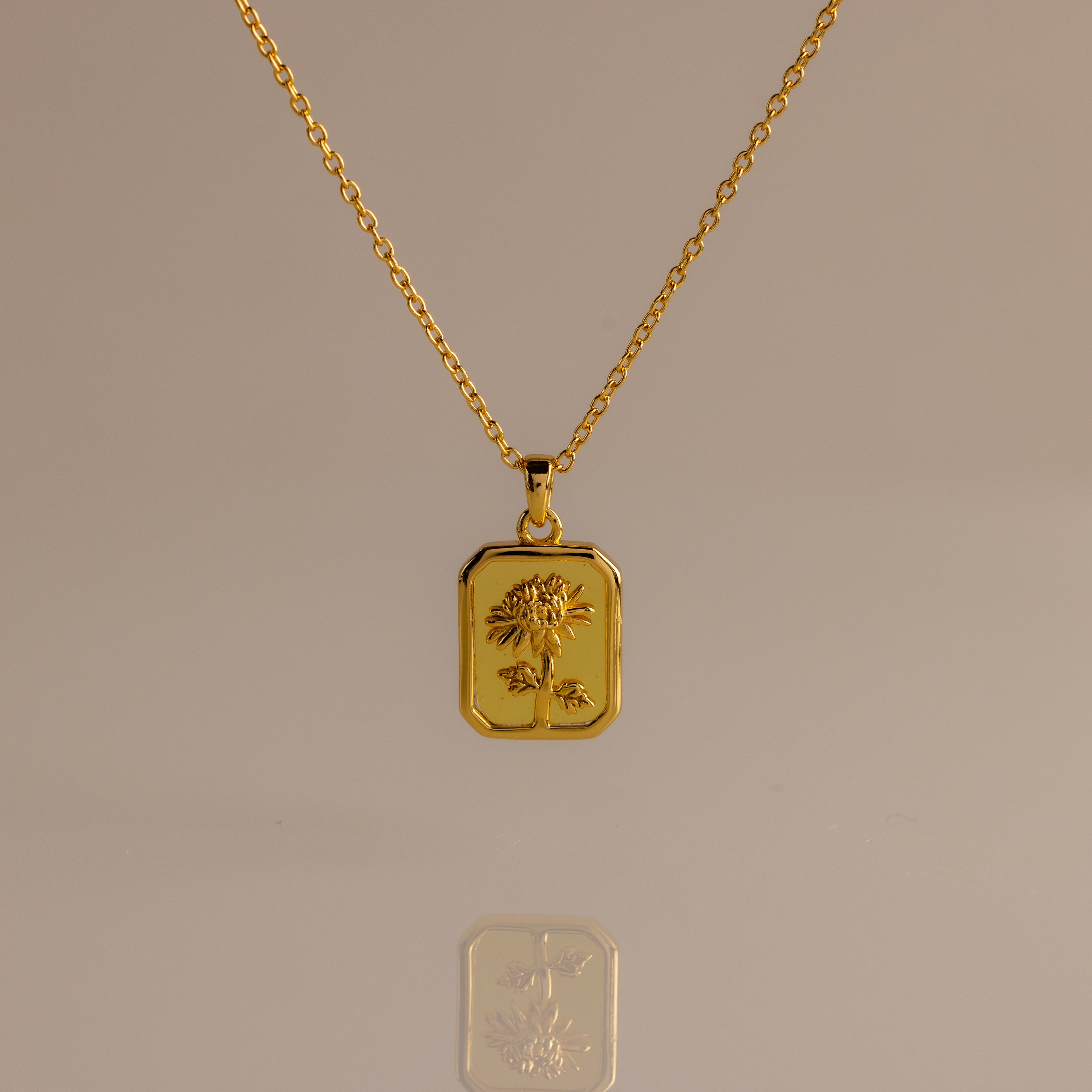 Topaz Birth Flower Charm Necklace featuring a rectangular pendant engraved with a delicate flower, displayed on a neutral background—an elegant addition to any jewelry collection.