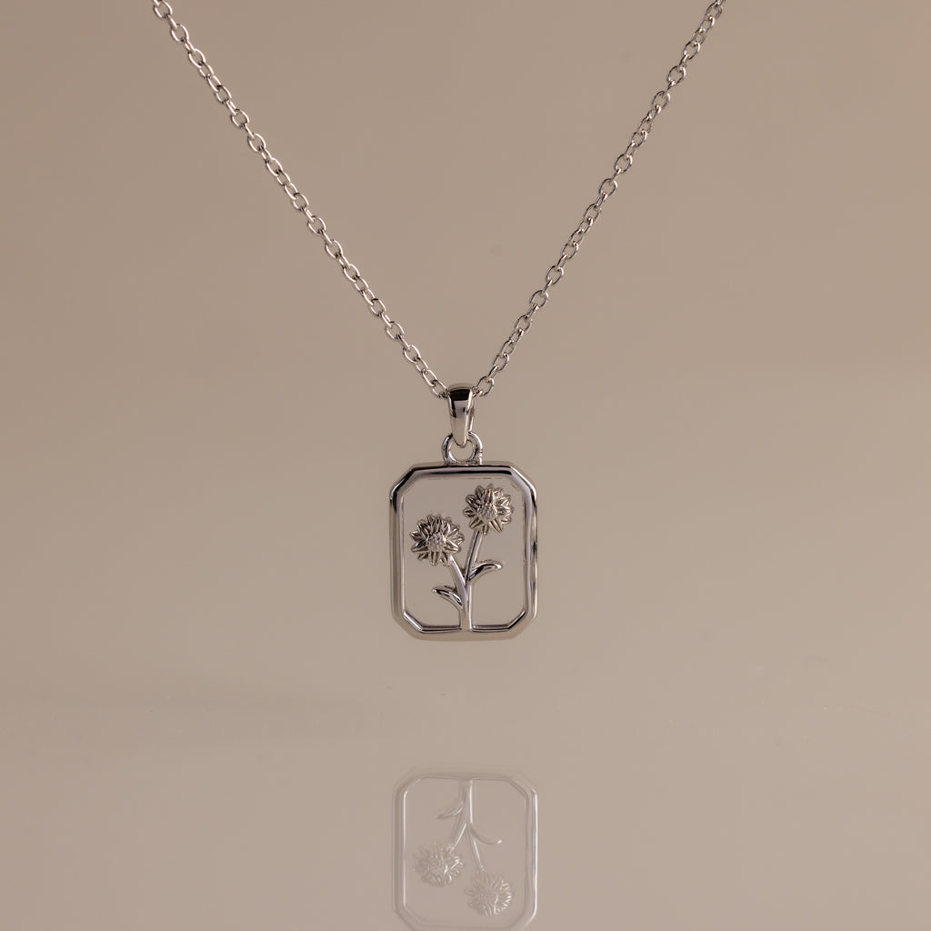 Diamond Birth Flower Charm Necklace with a rectangular pendant showcasing two outlined flowers on a neutral background—ideal for adding subtle floral elegance to any outfit.