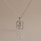 Opal Birth Flower Charm Necklace: A silver necklace with a rectangular pendant showcasing a delicate birth flower design on a light, reflective background—ideal for adding elegance to any outfit.