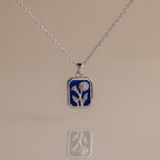 Sapphire Birth Flower Charm Necklace: Silver necklace with a blue rectangular pendant adorned with a delicate silver flower design, perfect for adding elegant style to any outfit.