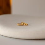 The Multipurpose Pave Ring Lock Set features two gold rings—one plain, one with a pavé-detailed clasp—resting on a smooth, light surface, making it ideal for jewelry customization enthusiasts.