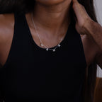 A woman wears a black tank top and the Alice Letter Name Necklace in Sterling Silver, personalized with "MAMA" charms—an ideal Christmas gift.