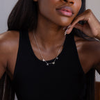 A woman in a black tank top wears the Alice Letter Name Necklace in Sterling Silver, customized with "MAMA"—a perfect Christmas gift.