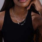 Woman in a black tank top wears the Carrie Multiple Name Necklace in Sterling Silver, featuring two personalized silver name pendants, shown from the shoulders up.