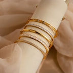 A Princess Diamond Tennis Bracelet, featuring sparkling princess-cut diamonds, displayed elegantly on a cream-colored stand with a soft beige fabric background.