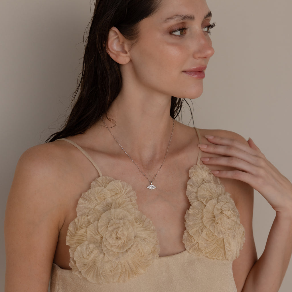 Model poses while wearing silver mirror chain with pave evil eye charm