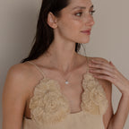 Model poses while wearing silver mirror chain with pave evil eye charm