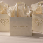Add the Gift Bag Add-On—featuring CAITLYN MINIMALIST branding, a geometric heart design, and floral tissue paper—for an elegant finishing touch to your gift wrapping.