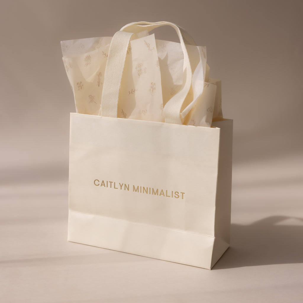 Cream-colored Gift Wrap Add-On bag with elegant text and floral tissue paper inside, providing a stylish finishing touch to your present, shown on a neutral background.