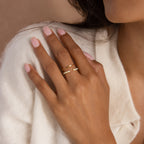 A woman's hand with light pink nails wears the Baguette Opal Ring Set, resting on a cream-colored sweater.