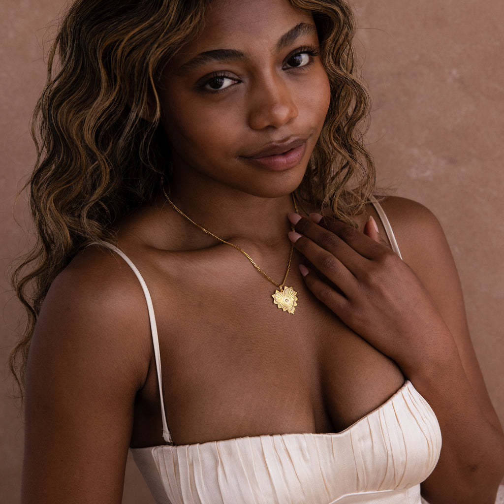 Model wears gold ribbed Diamond Heart Charm on dainty necklace