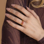 A hand with nude nail polish wears the Lace Birthstone Rings Set, featuring gold minimalist rings with red stones, resting on a purple sheer-sleeved arm.