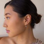 A woman with a bun in her hair wears Pave Spike Huggies, highlighting their edgy cone shape and sparkling pavé-set design.
