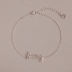 The Cursive Name Bracelet in Sterling Silver features a delicate "Avery" in cursive and a heart charm on an adjustable chain—a perfect, personalized jewelry piece.