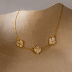 Gold necklace with three clover-shaped charms featuring the letters M, R, and S on a neutral background, reflecting the elegance of the Pearl Clover Letter Bracelet in 18K Gold.