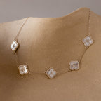 A Pearl Clover Letter Bracelet in Sterling Silver, featuring flower-shaped charms with the letters Q, R, A, C, and R, is showcased on a tan mannequin.