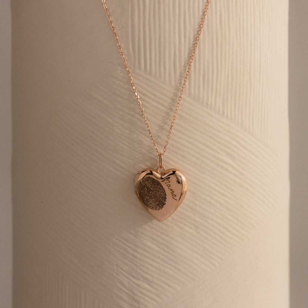 Flatlay of our Fingerprint Heart Locket Necklace in Rose Gold