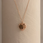 Flatlay of our Fingerprint Heart Locket Necklace in Rose Gold